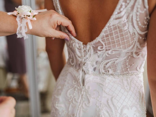 Mother preparing her daughter for the wedding day. Bride getting ready