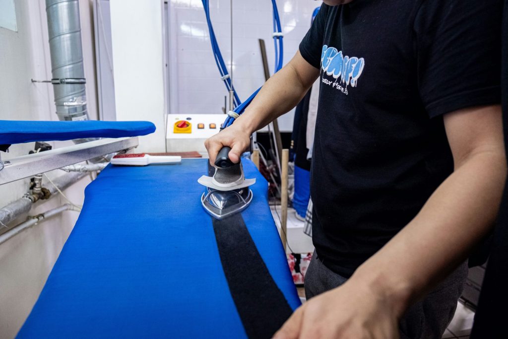 a man is using a sanding machine on a blue surface