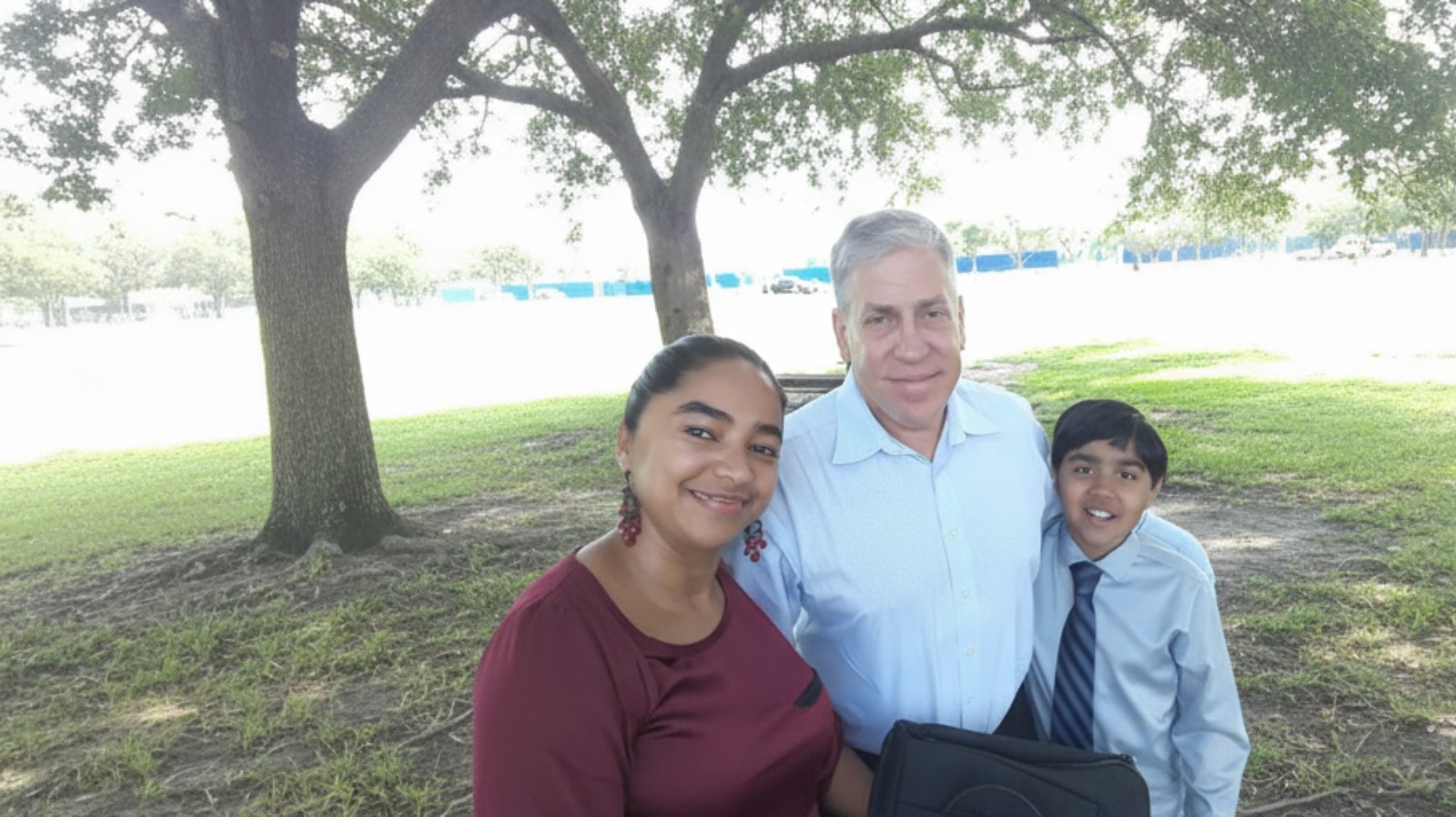 A man standing in white shirt with two children