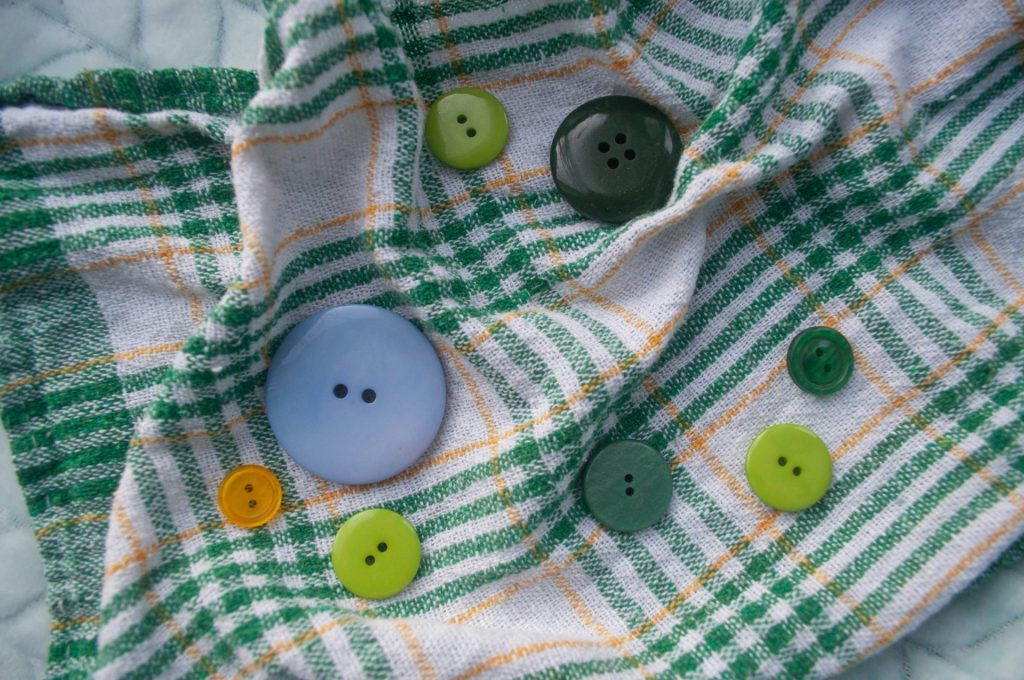 A green and white checkered shirt with buttons on it